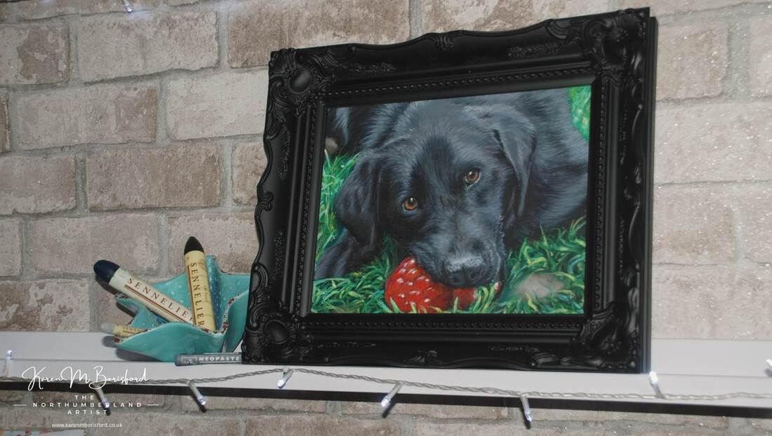 An oil pastel painting of a black Labrador using Sennelier and Caran d'Ache Neopastel oil pastels framed in a black ornate frame